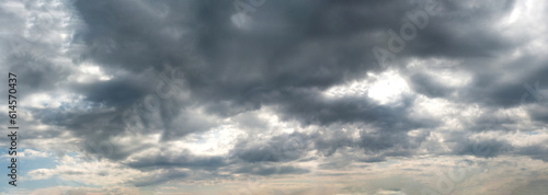 A panoramic view of scattered Dark clouds against a blue sky