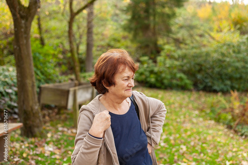 Senior woman walking in the park in autumn. Health care concept.