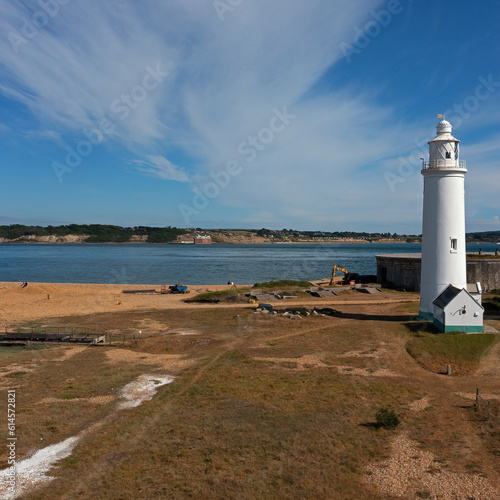 Beautiful lighthouse at Hurst Point on the waters edge on South Coast in England. Lighthouse is working today, and was converted from acetylene to electric power in 1997. Square image, space for text. photo