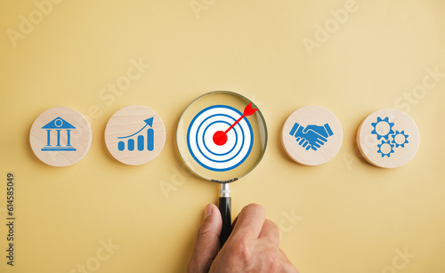 Focus on target icon through a magnifying glass, representing essence of start-ups, creative ideas, and innovation. It symbolizes motivation, planning, development, leadership for customer targeting