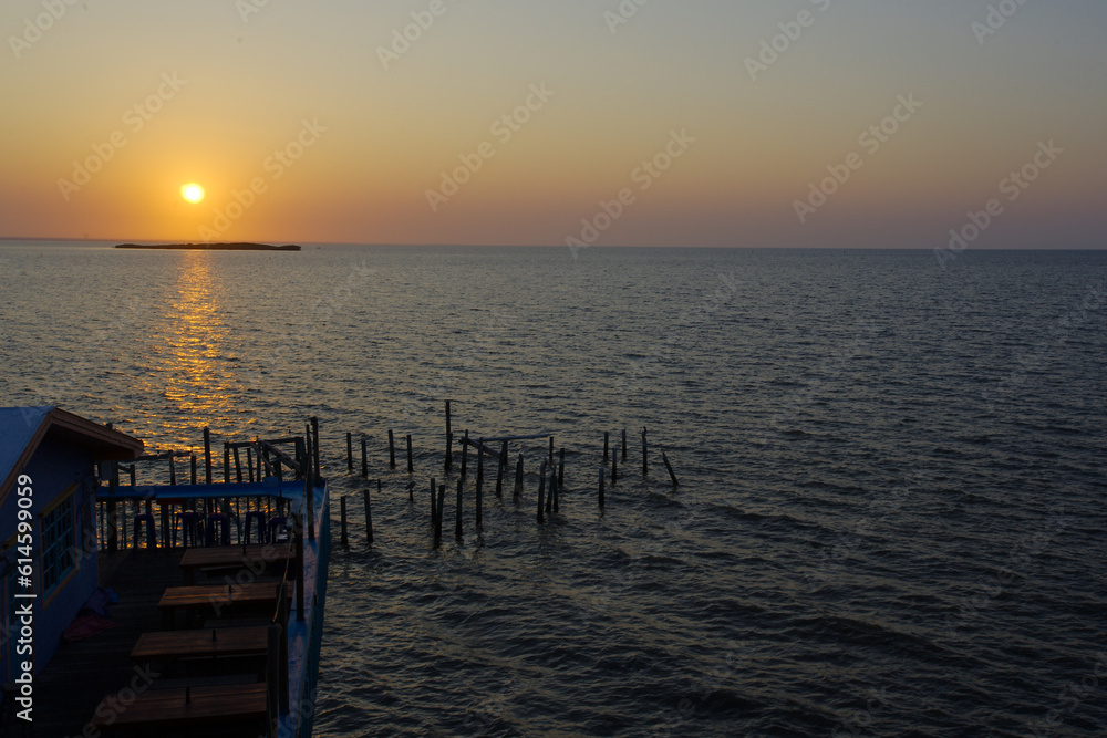 Sunrise overlooking Fishing dock in Cedar Key Florida. On a sunny day with calm waters. Wood pier poles in water with dim lights. Sunrise overlooking Fishing dock in Cedar Key Florida. On a sunny day with calm waters. Wood pier poles in water with dim lights.