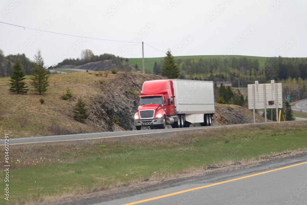 truck carrying cargo through green hills