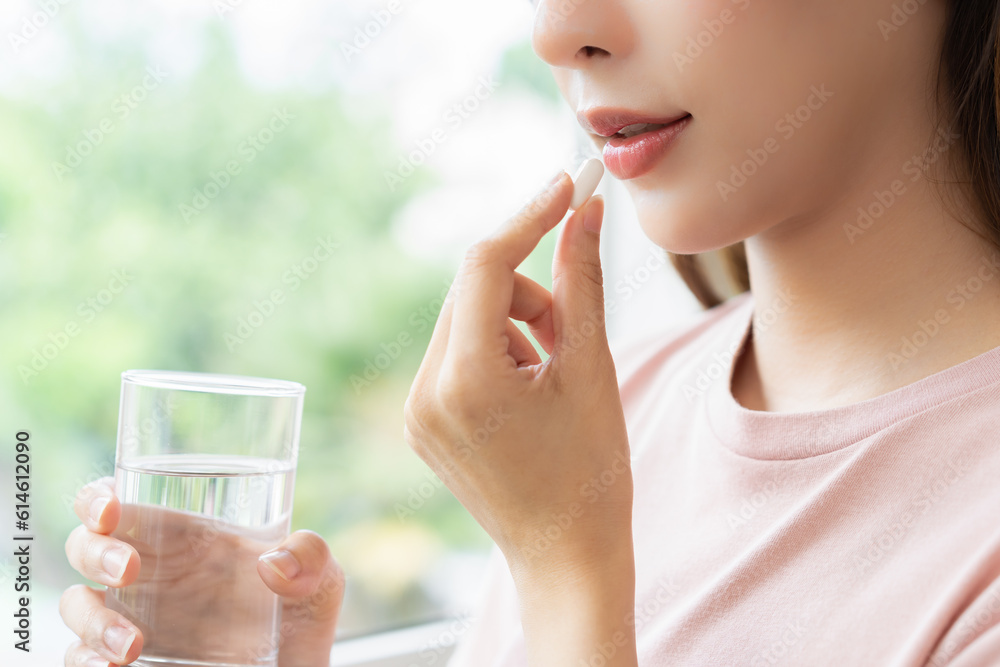 Dietary supplement asian young woman hand holding medical pill capsule, take or eat vitamin in mouth for treatment, sick female taking medicines drinking with water at home, pharmacy and healthcare. Dietary supplement asian young woman hand holding medical pill capsule, take or eat vitamin in mouth for treatment, sick female taking medicines drinking with water at home, pharmacy and healthcare.