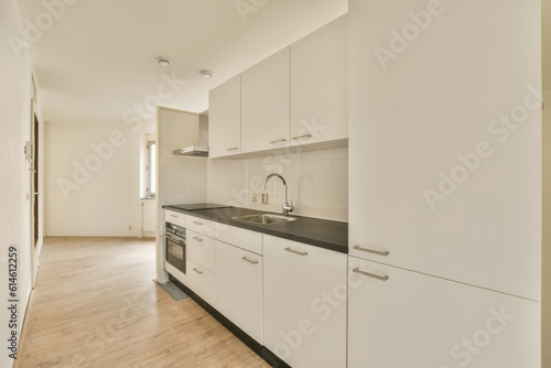 Photography an empty kitchen with white cabinets and black counter tops on the floor in a ne