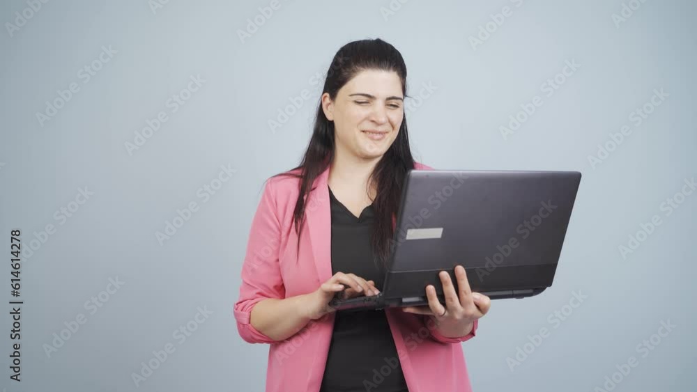 Satisfied business woman looks at laptop and approves. Satisfied business woman looks at laptop and approves.