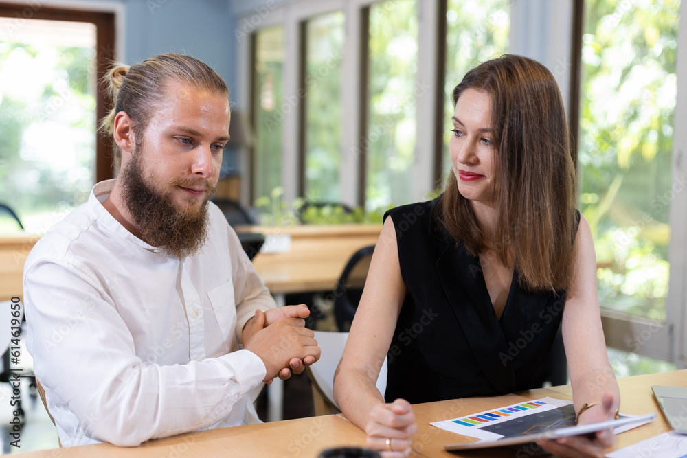 Obraz premium Business team using tablet presentation meeting. Sales Marketing Group is analyzing investment market. Male manager shows marketing analysis graph on tablet to female assistant.