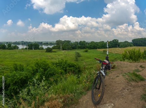 shooting a panorama of the outskirts of the city near the river with a smartphone mounted on a gimbal, which is fixed on the seat of a bicycle - a sunny summer day