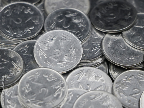 closeup of a collection of indian 2 ( two ) rupee coins made of silver in a mixed up pile 