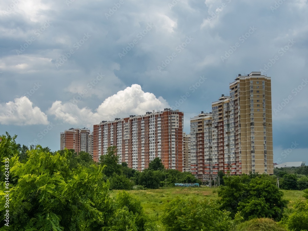 modern high-rise buildings on the outskirts of the city of Krasnodar against the background of clouds on a summer day