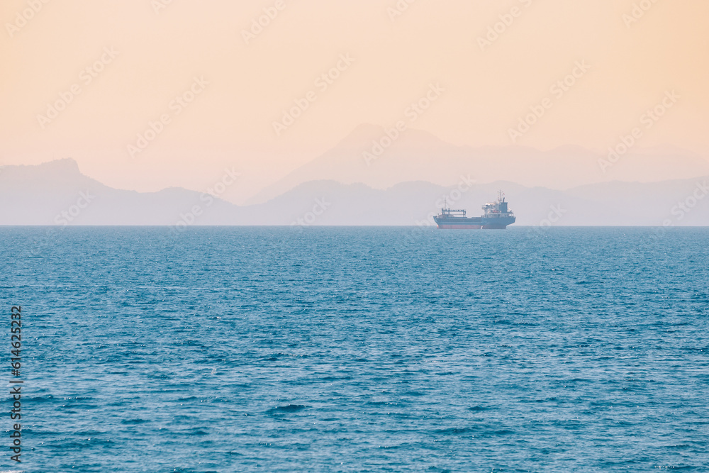 Cargo freight tanker ship in the distance of a vast sea Cargo freight tanker ship in the distance of a vast sea