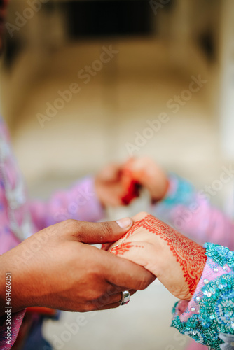Young married couple holding hands, Malay ceremony wedding day.