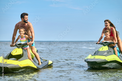 Family enjoyed active vacation outdoor sports and water recreation, jet-skiing on the water. photo