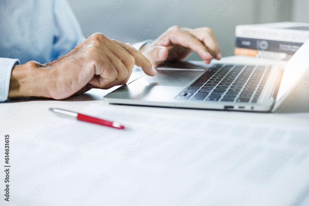A man typing on computer keyboard searching data from internet to start new business SME after he resigning from the company, Close-up view A man typing on computer keyboard searching data from internet to start new business SME after he resigning from the company, Close-up view