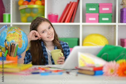 girl with cup using laptop at home at desk