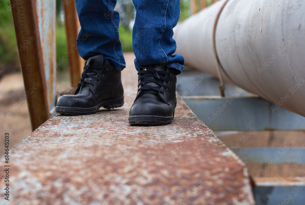 Wear safety shoes to ensure safety at work. construction workers wear safety shoes. People with factory safety concept Wear safety shoes to ensure safety at work. construction workers wear safety shoes. People with factory safety concept
