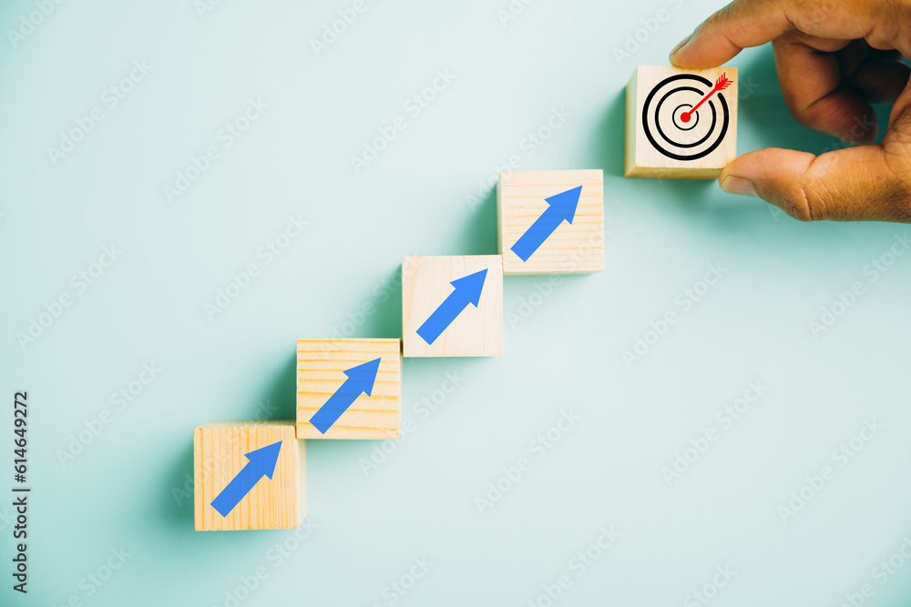 Wooden blocks featuring a Target icon atop rise up arrows. Bar graph ...