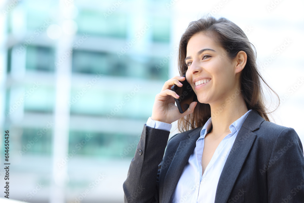 Happy executive talking on phone walking in the street Happy executive talking on phone walking in the street
