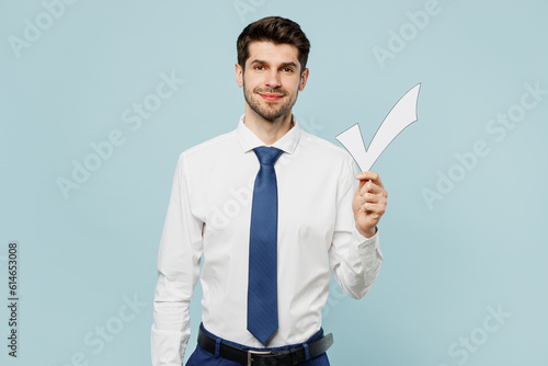 Young cheerful fun employee IT business man corporate lawyer wear classic formal shirt tie work in office hold in hand check mark show thumb up isolated on plain pastel blue background studio portrait