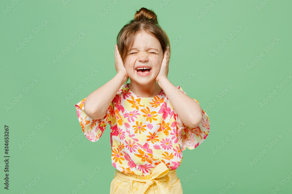 Little sad child kid girl 6-7 year old wear casual clothes cover ears with hands fingers do not want listen scream isolated on plain pastel green background Mother's Day love family lifestyle concept Little sad child kid girl 6-7 year old wear casual clothes cover ears with hands fingers do not want listen scream isolated on plain pastel green background Mother's Day love family lifestyle concept