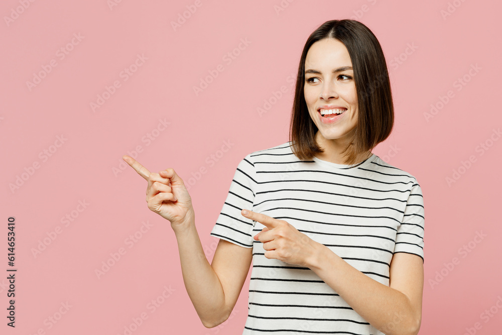Young woman she wears casual clothes t-shirt point index finger aside indicate on workspace area copy space mock up isolated on plain pastel light pink background studio portrait. Lifestyle concept. Young woman she wears casual clothes t-shirt point index finger aside indicate on workspace area copy space mock up isolated on plain pastel light pink background studio portrait. Lifestyle concept.