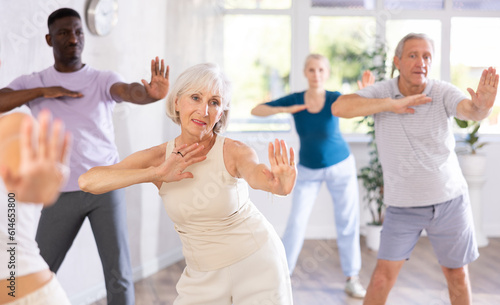 In fitness studio at group class, senior woman has fun and dances learn to move energetically to beat of music. Modern dance school, active lifestyle