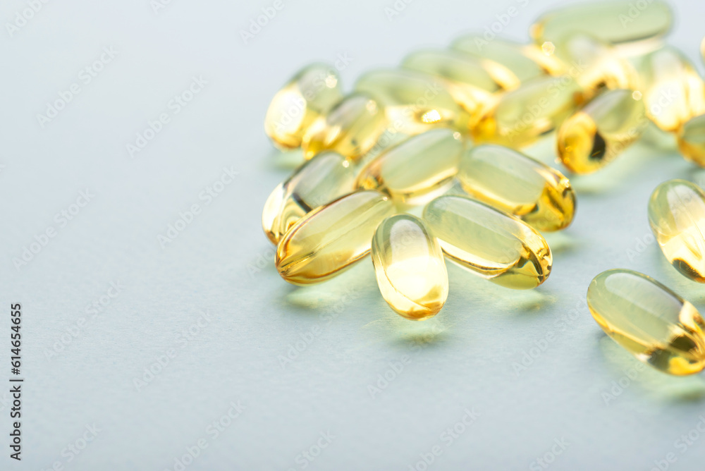 Omega 3 fish liver oil capsules on blue background. Close up, front view. Omega 3 fish liver oil capsules on blue background. Close up, front view.