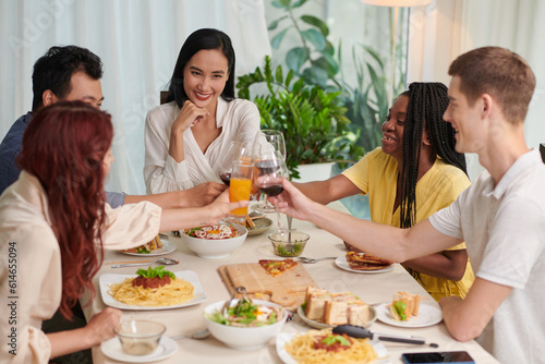 Happy group of friends toasting over dinner table
