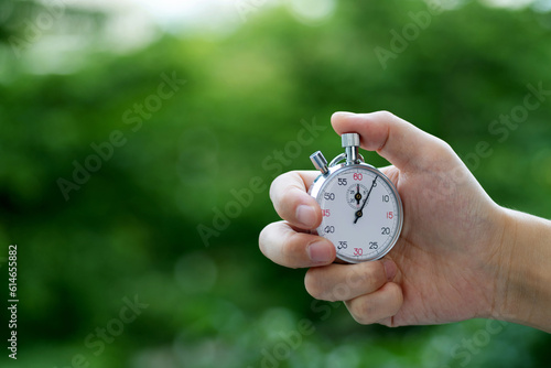 People hand holding stopwatch outdoors photo