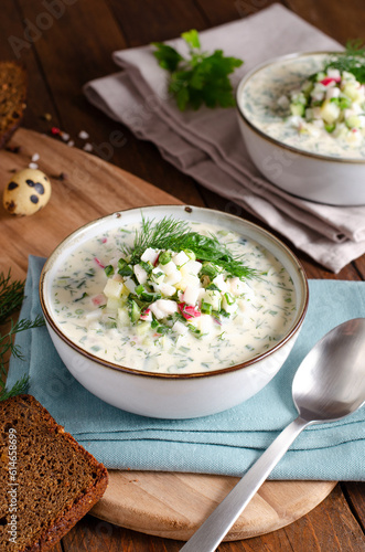 Cold Okroshka Soup with Eggs, Vegetables, Meat, Herbs and Kefir on a Wooden Background, Summer Soup