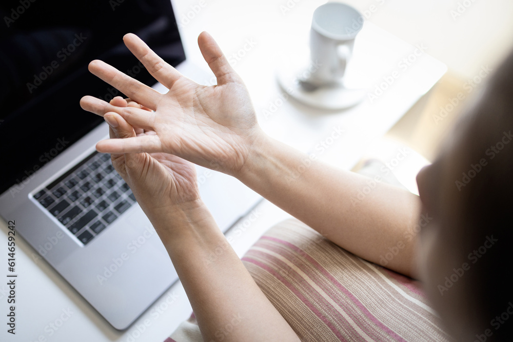 Fototapeta premium Female office worker suffering from trigger finger disease,painful in fingers and wrist,hurt the hand,health problems,Concept of Trigger Finger,Digital Flexor Tenosynovitis or Stenosing Tenosynovitis
