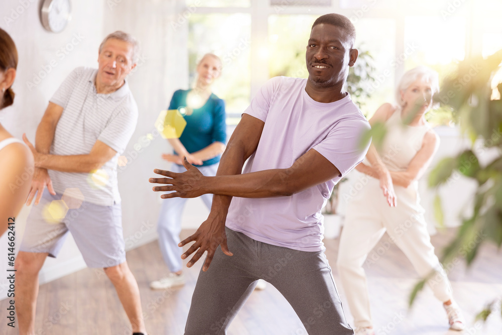 Group of multinational sports aged people rehearsing hip hop dance in dance hall