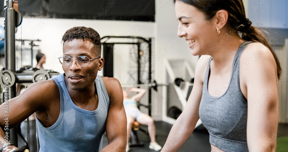Fit trainer explaining exercise to woman in gym