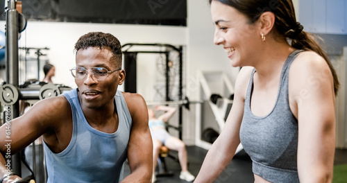 Fit trainer explaining exercise to woman in gym