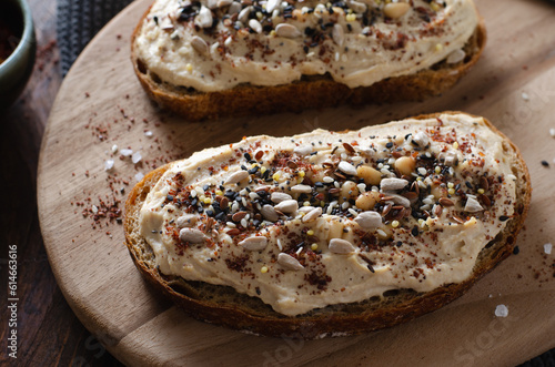 Hummus Toast with Rustic Bread, Vegetarian Snack or Breakfast on Wooden Background