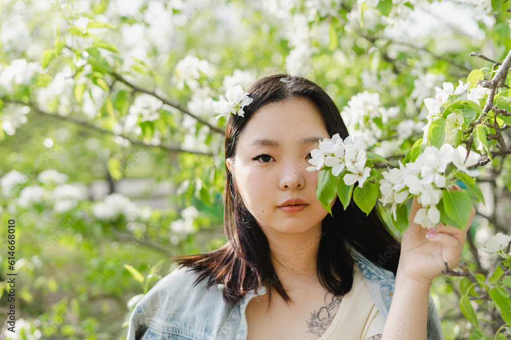 Young woman holding branch with white flowers Young woman holding branch with white flowers