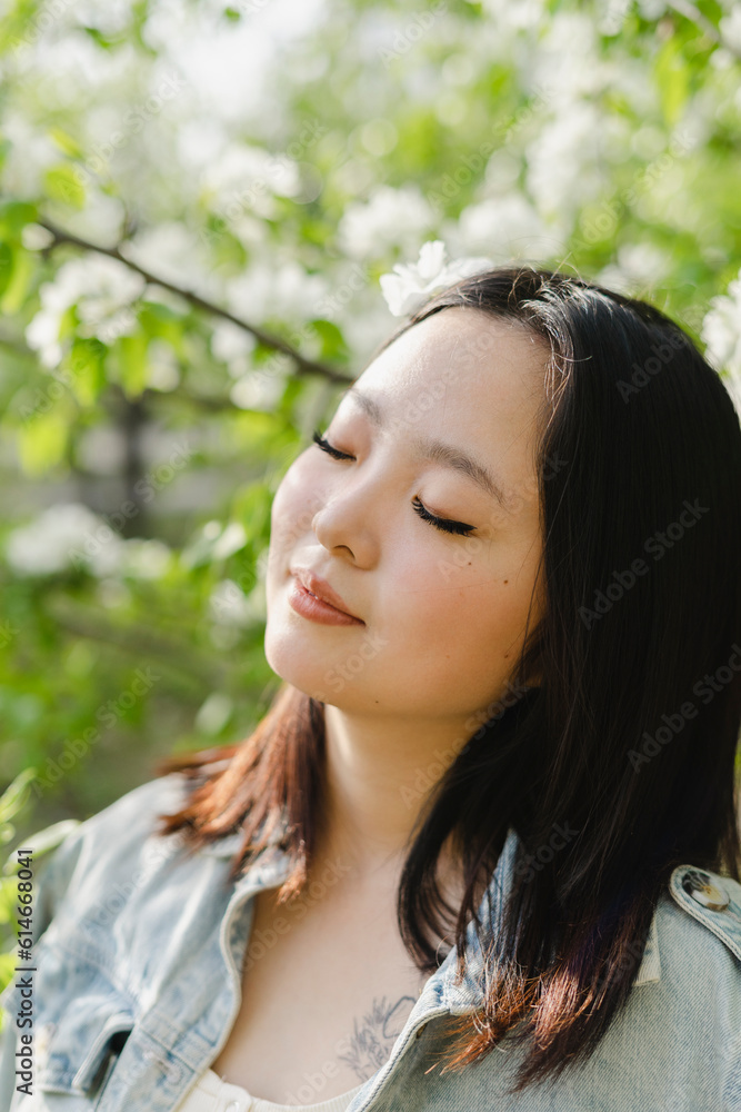Young woman with eyes closed by flowering tree Young woman with eyes closed by flowering tree