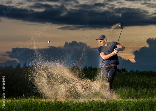 Man hitting golf ball at dusk