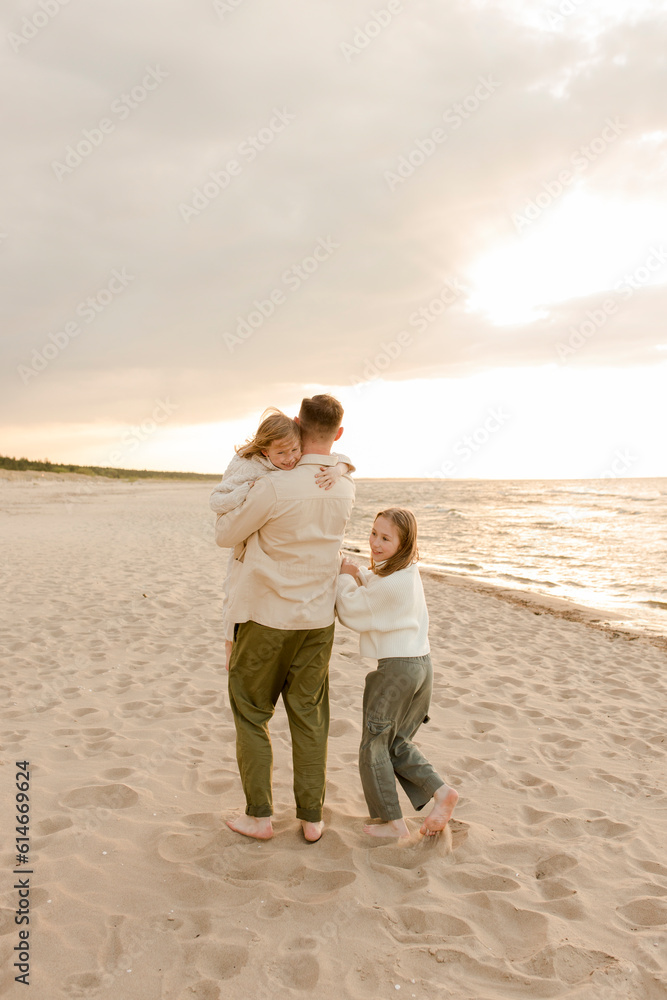 Happy daughters with father walking at beach Happy daughters with father walking at beach
