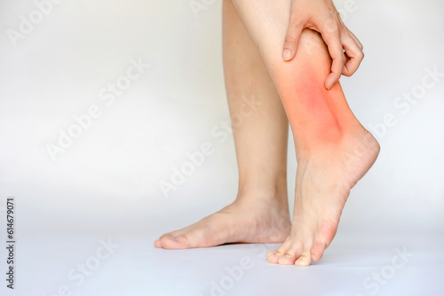 Woman's ankle with inflammation and pain showing red area. Health care concept.