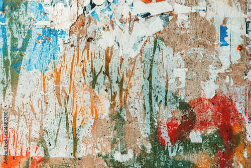 Textured surface of torn poster paper on concrete wall as grunge texture and background