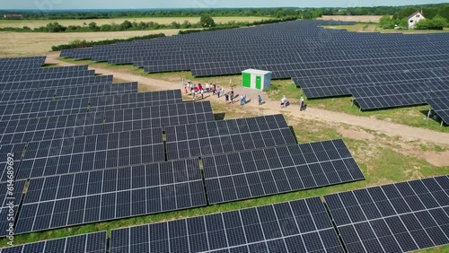 Groupe de gens marchand au milieu de champ de panneau solaire