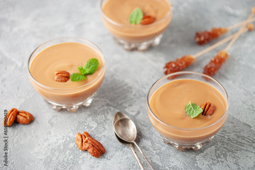 Homemade butterscotch pudding in glass cream bowl on the table. National Butterscotch Pudding Day Homemade butterscotch pudding in glass cream bowl on the table. National Butterscotch Pudding Day