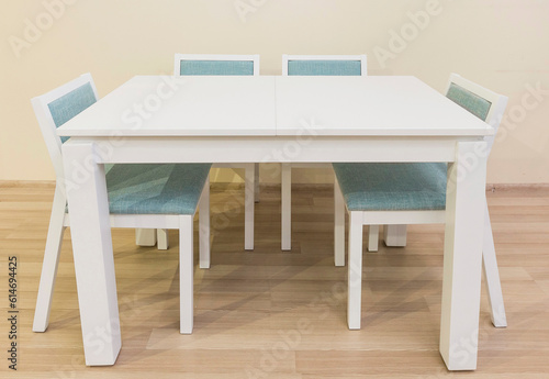White table with four legs and four chairs with turquoise upholstery, furniture designed for office and home