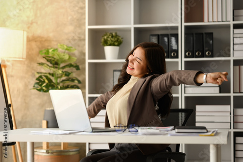 Wallpaper Mural Carefree millennial businesswoman relaxing at workplace, stretching arms, taking break from work on laptop Torontodigital.ca