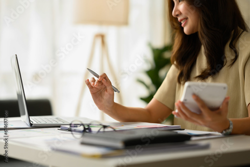 Businesswoman working on corporate project strategy or marketing plan  using calculator at desk