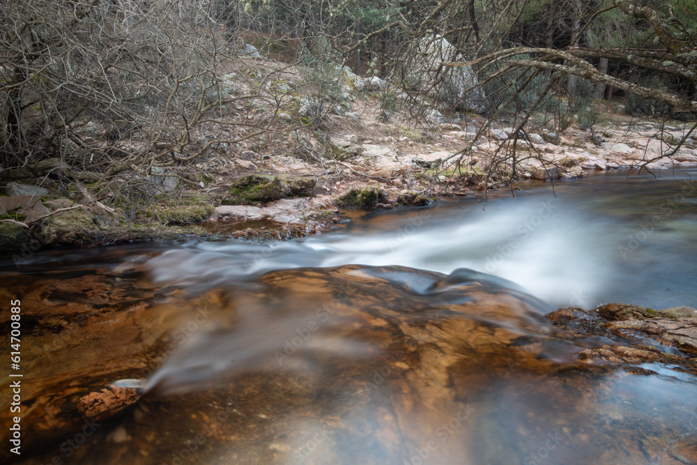 Fotografía del río de La Pedriza con una cascada y aguas cristalinas: La imagen muestra el río de La Pedriza fluyendo suavemente entre las rocas, con una hermosa cascada en el fondo. 