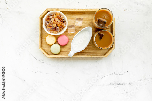 Iced cold coffe with macaroons and caramel suger for summer breakfast