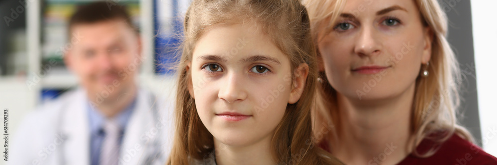 Portrait of mother and daughter on background of pediatrician medical doctor. Medical examination and family insurance concept Portrait of mother and daughter on background of pediatrician medical doctor. Medical examination and family insurance concept