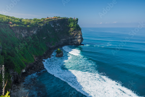 Scenic rocky cliff and ocean in Uluwatu, Bali. Popular tourist place with balinese temple