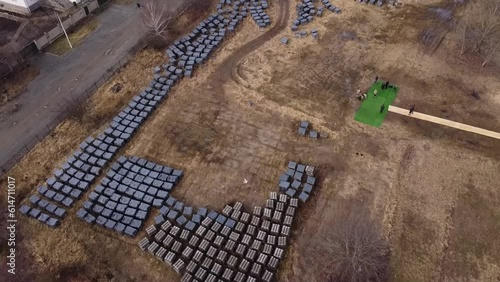 Drone shot moving over the mass buriel site at the Church of Saint Andrew and Pyervozvannoho All Saints. Ukraine, Bucha - Kyiv Oblast.